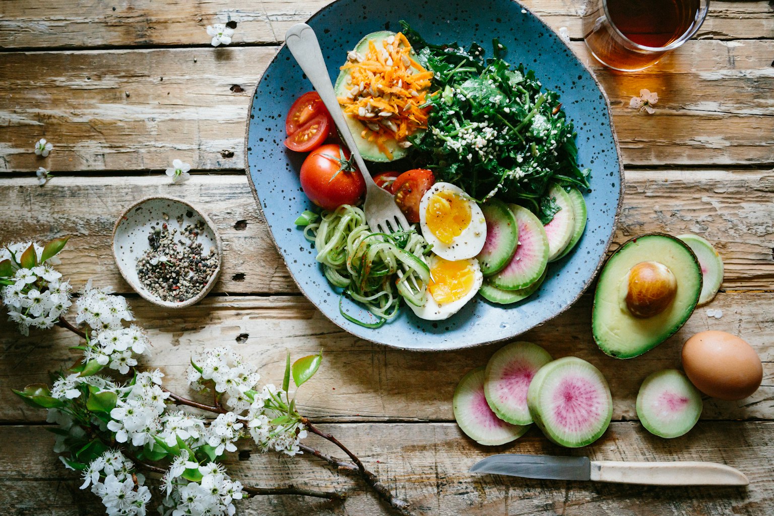 A balanced bowl of greens, avocado, tomatoes and eggs